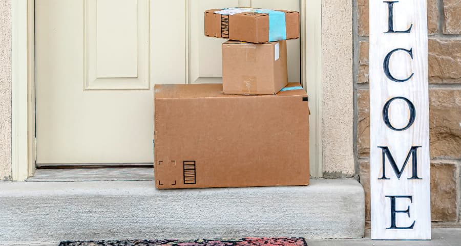 Packages on the doorstep of a home with a welcome sign in Newburgh